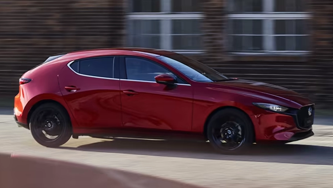 Vue avant dynamique de la Mazda 3 sur fond sombre