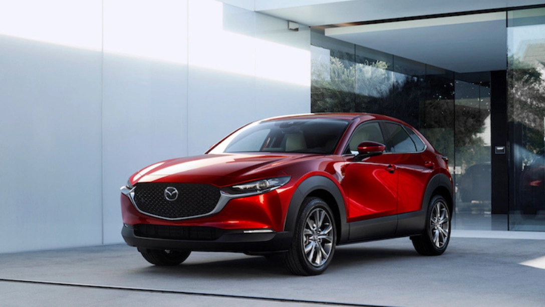 Vue latérale du Mazda CX-30 sur fond noir, mettant en avant son design élégant